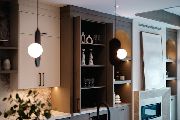 Modern pendant light fixtures illuminating kitchen cabinetry